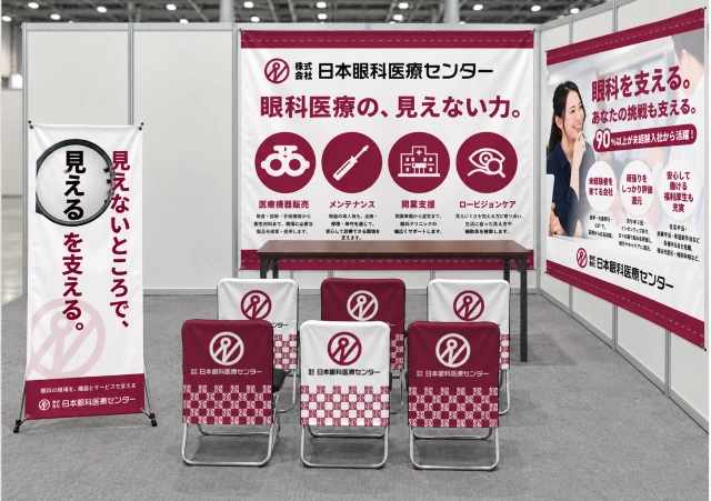 株式会社日本眼科医療センターの合同説明会ブース設置イメージ。えんじ色と白を基調に、眼科医療の専門性を伝えるタペストリー・ロールアップバナー・イスカバーを配置した統一感のある採用ブースデザイン。